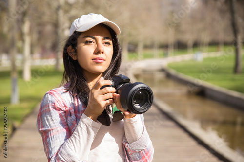 Focused young photojournalist working outdoors