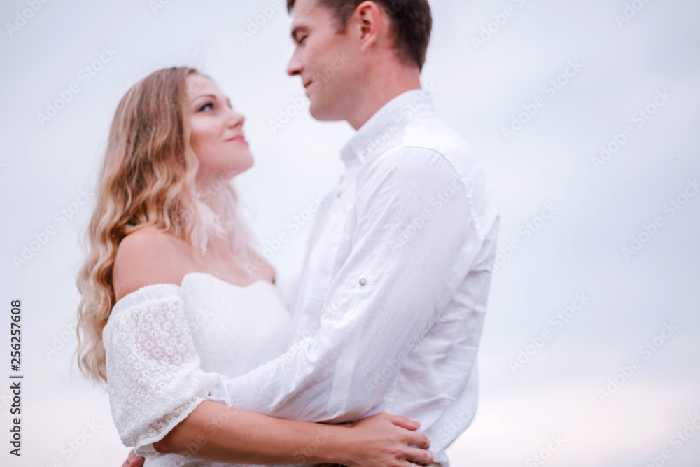 Bride and groom look at each other against the blue sky