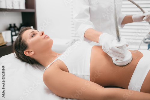 procedure removing cellulite on female abdomen, cavitation belly massage