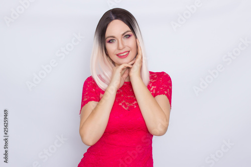 Young blonde woman over white background in bright pink dress © yevgeniya131988
