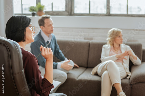 Concentrated short-haired female psychotherapist pointing on necessary information