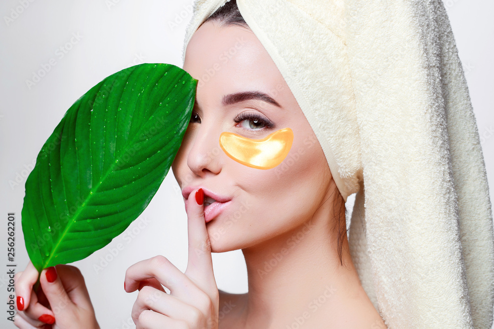 Portrait of young beautiful woman with healthy glow perfect smooth skin  holds green tropical leaf. Gold cosmetics collagen hydrogel patch. Lifting  anti-wrinkle mask under eyes. Skincare concept. Stock Photo | Adobe Stock