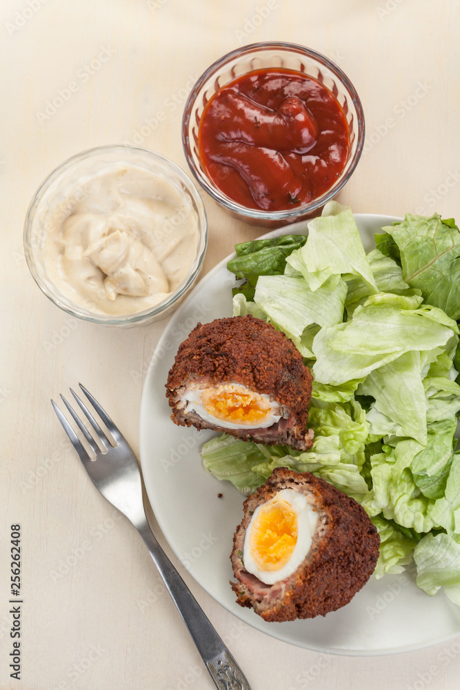 Scotch eggs cut in halves on a plate