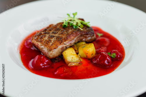 Steak from fillet of a duck with caramelized strawberry and an eggplant