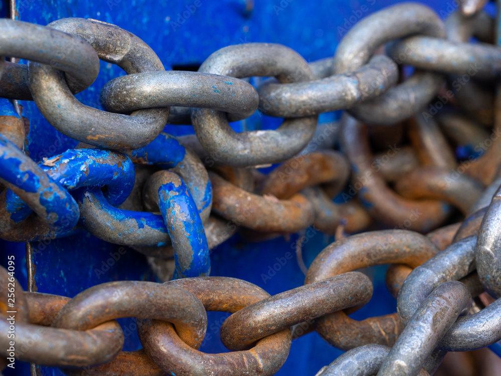 Iron big chain and hook on the blue door. The lock on the chain. Iron big chain and hook on the blue door. The lock on the chain.