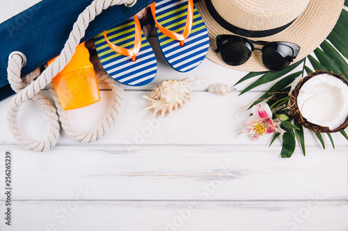 Summer holiday vacation concept. Beach bag and accessories on white wooden table. Top view and flat lay