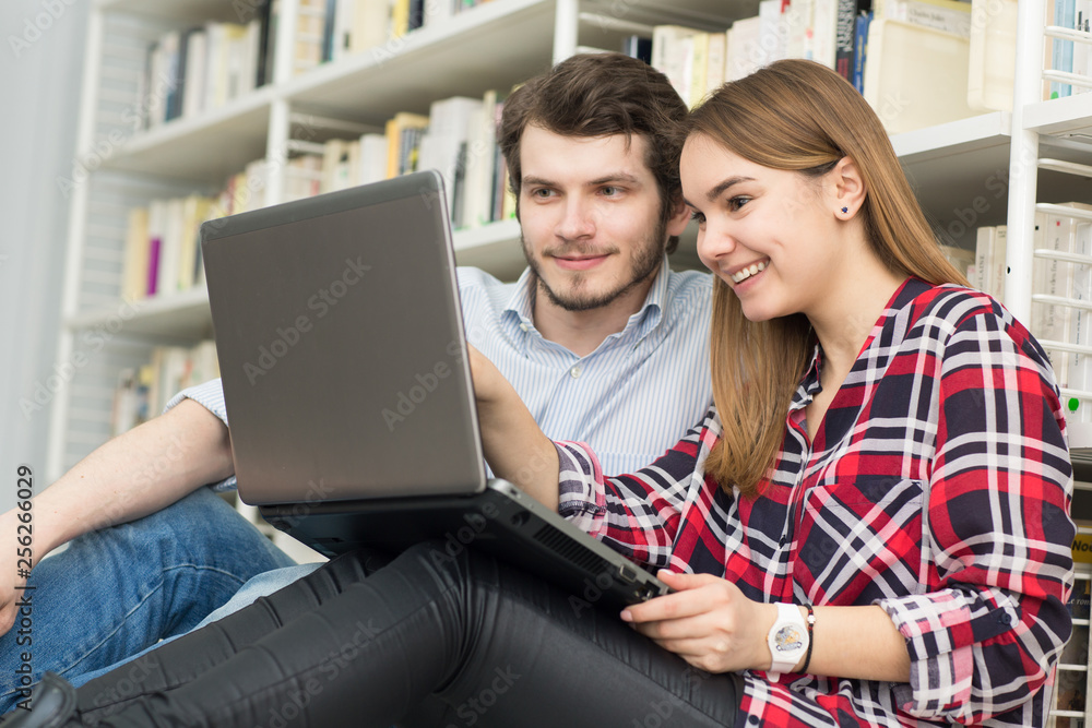Young cheerful college students studying together at the library Young cheerful college students studying together at the library