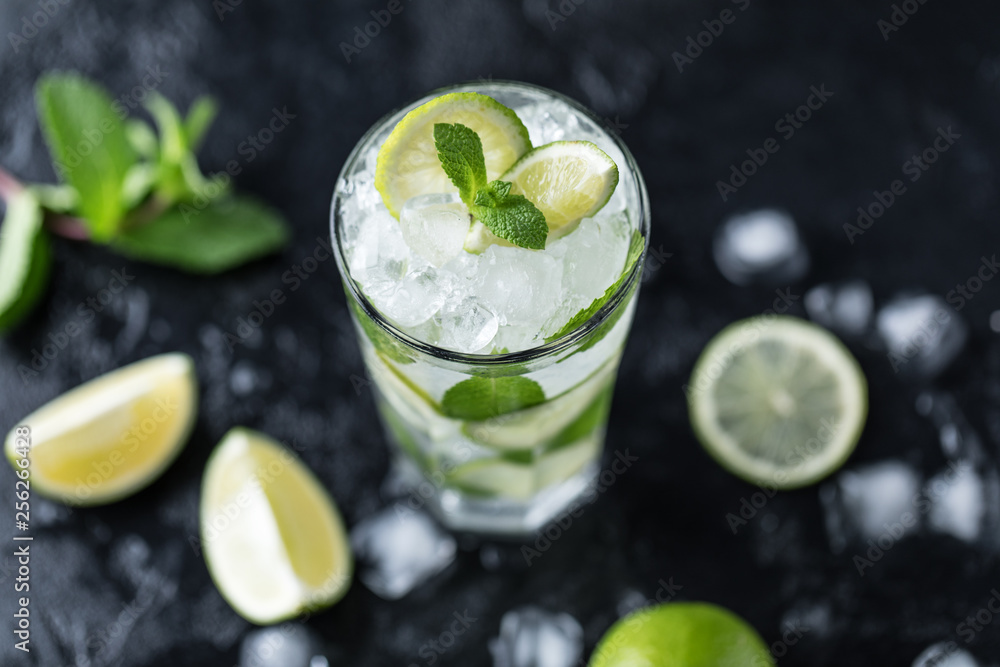 Mojito cocktail with lime and mint in highball glass on a dark stone background. Fresh summer cocktail Mojito cocktail with lime and mint in highball glass on a dark stone background. Fresh summer cocktail