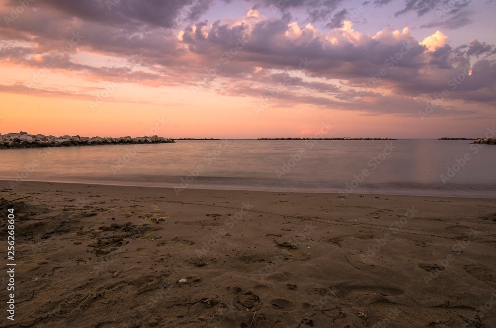 Paesaggio marino con spiaggia e mare calmo al tramonto