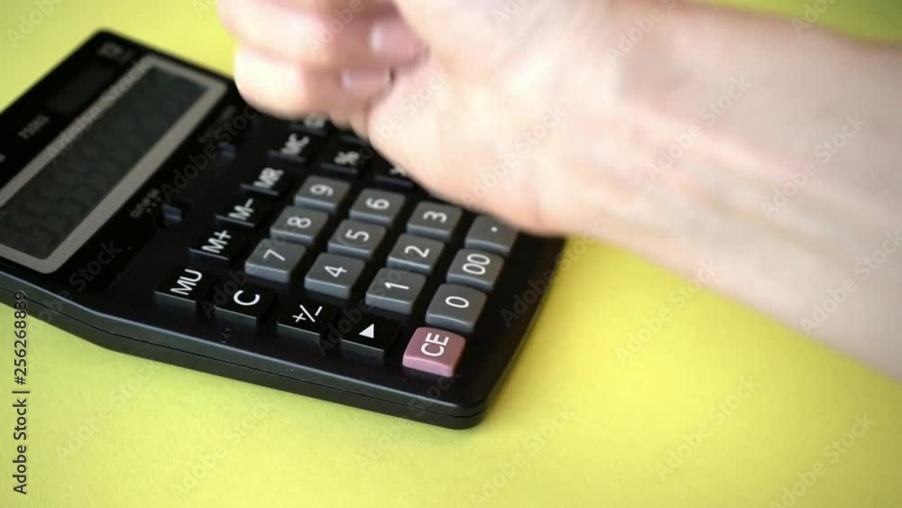 A woman tries to fix a broken calculator by pounding it A woman tries to fix a broken calculator by pounding it
