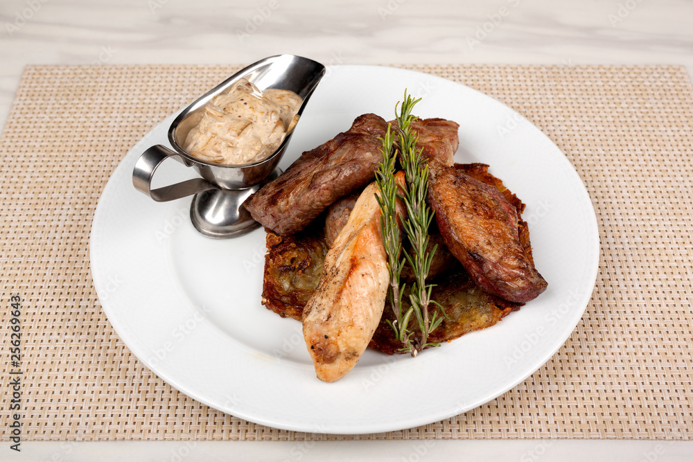 Fried meat in an assortment on a white plate with sauce. Fried meat in an assortment on a white plate with sauce.