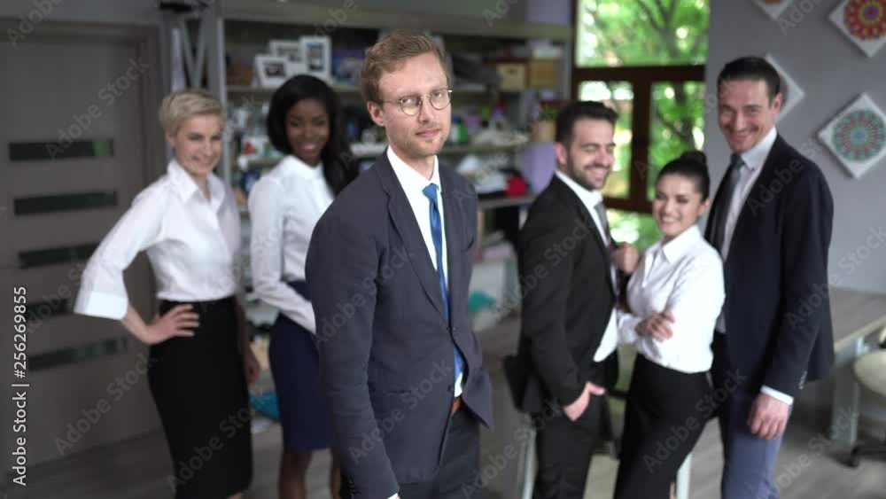 Confident businessman standing in front of his successful team Confident businessman standing in front of his successful team