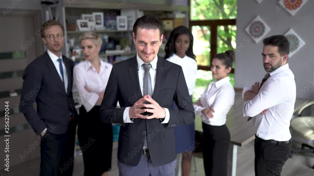 Confident businessman standing in front of his successful team Confident businessman standing in front of his successful team