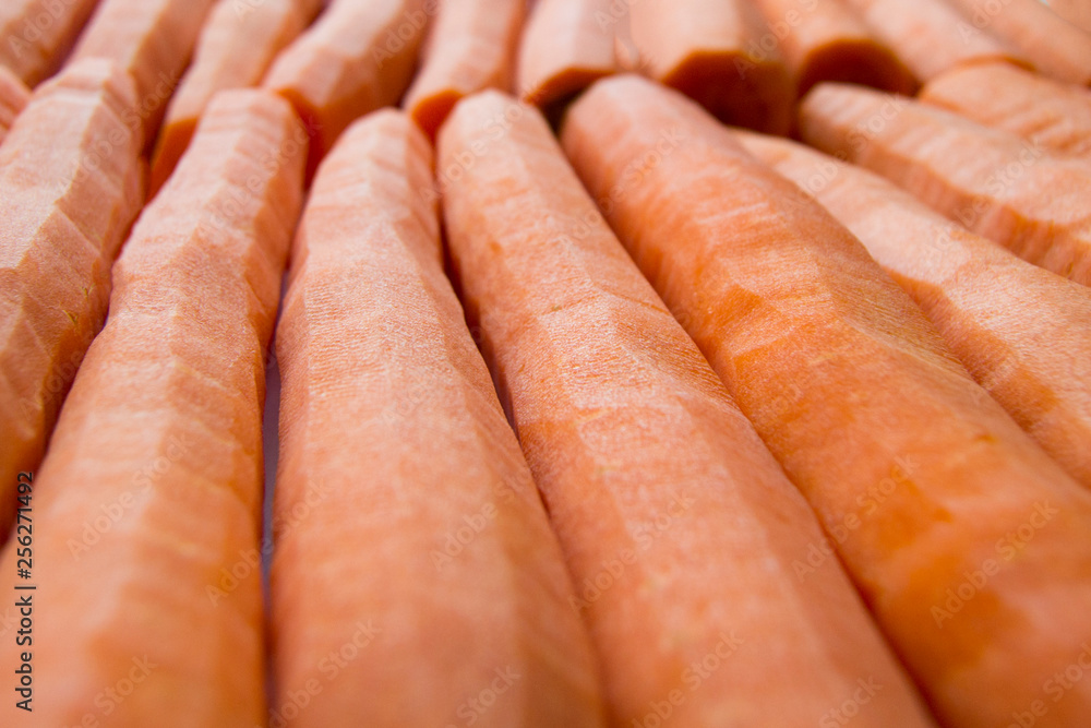 Peeled carrots in a row for a juicy background