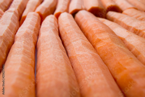 Obraz na płótnie Peeled carrots in a row for a juicy background w salonie