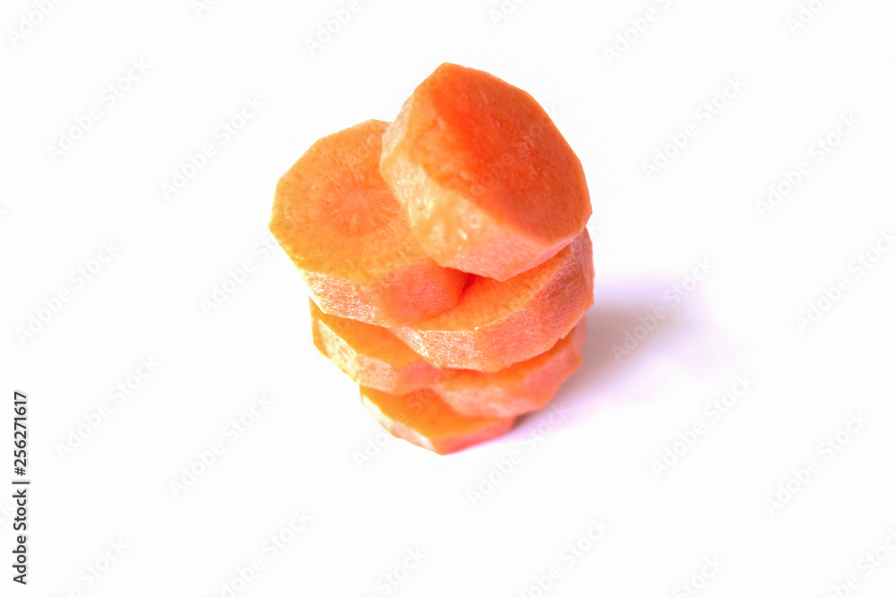 Tower of fresh carrot circles on a white background
