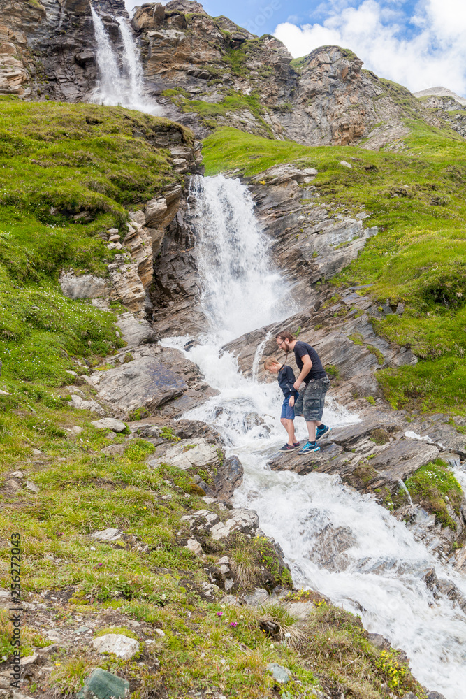 A father and son at the alpine waterfall