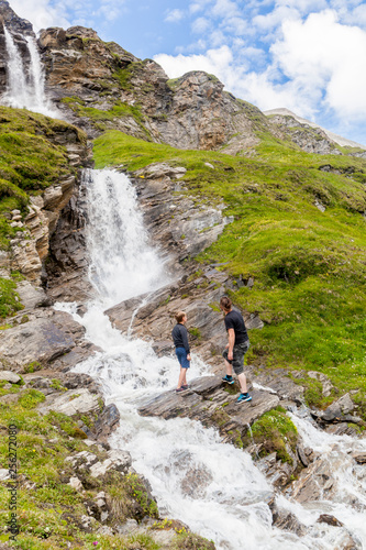 A father and son at the alpine waterfall