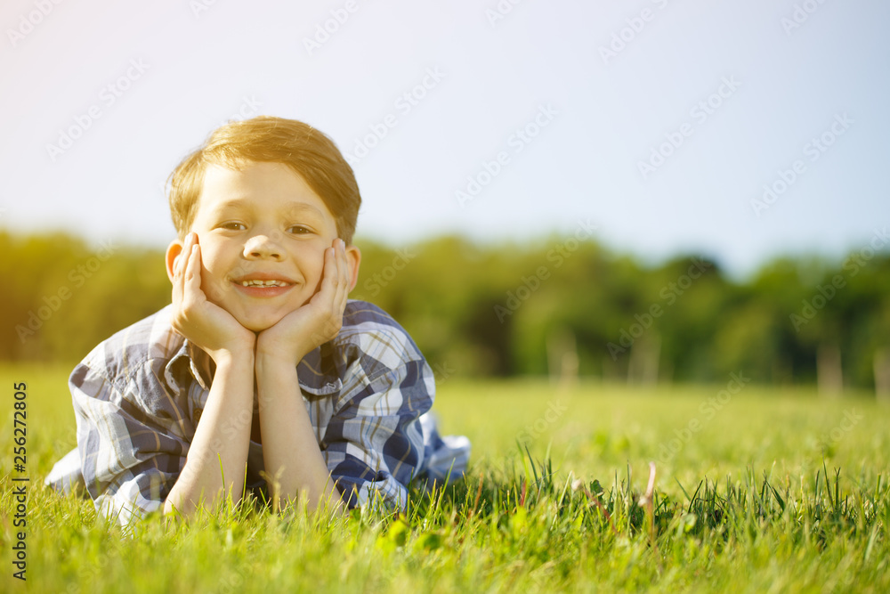 Fototapeta premium Young boy relaxing outdoors at the park
