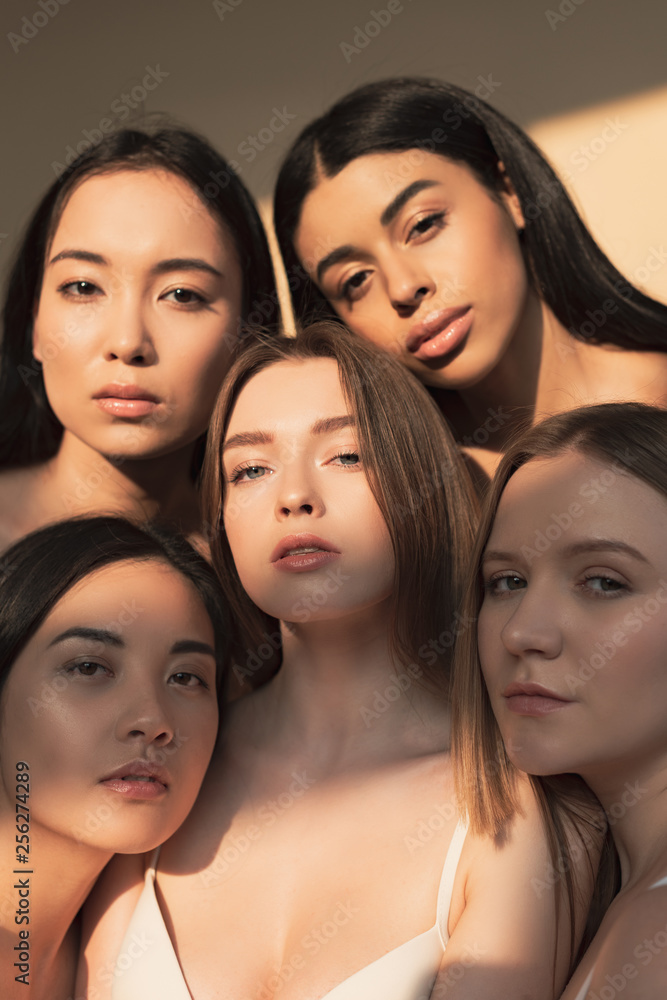 Obraz premium five attractive multicultural young women looking at camera in sunlight