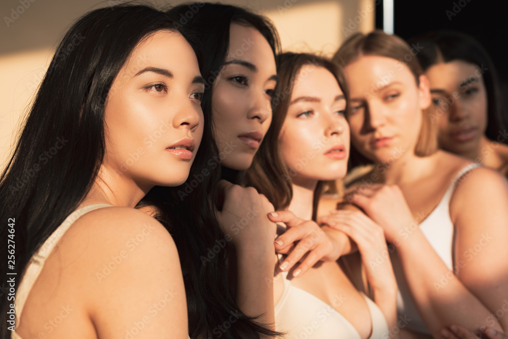 Obraz premium selective focus of five multicultural girls standing together in sunlight