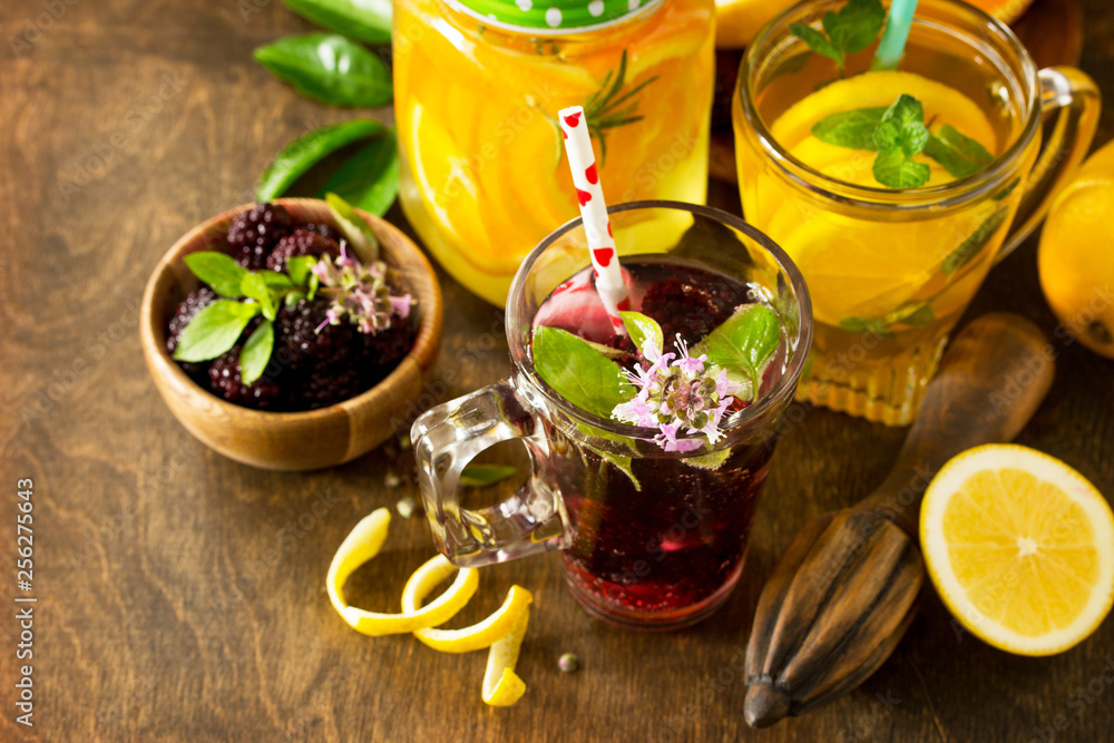 Refreshing summer berry Lemonade, lemon mint Tea and orange Lemonade with rosemary on wooden table in rustic style. Refreshing summer berry Lemonade, lemon mint Tea and orange Lemonade with rosemary on wooden table in rustic style.