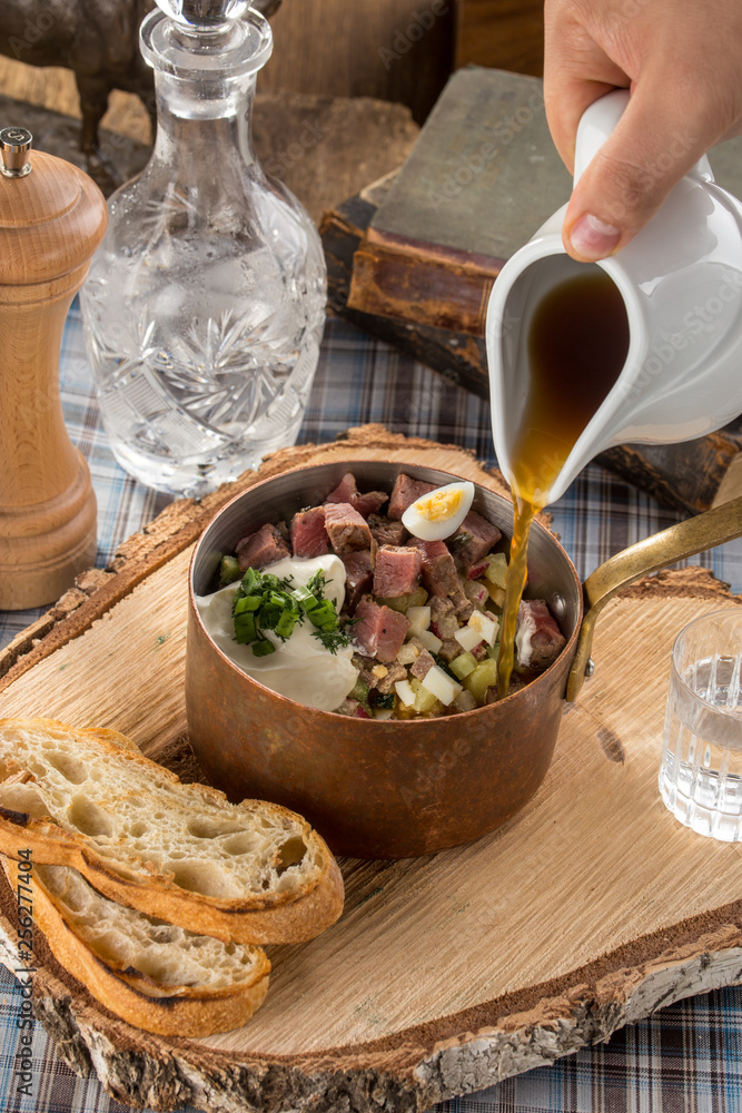 Summer cold soup okroshka with radish, cucumber and beef on wooden board Summer cold soup okroshka with radish, cucumber and beef on wooden board