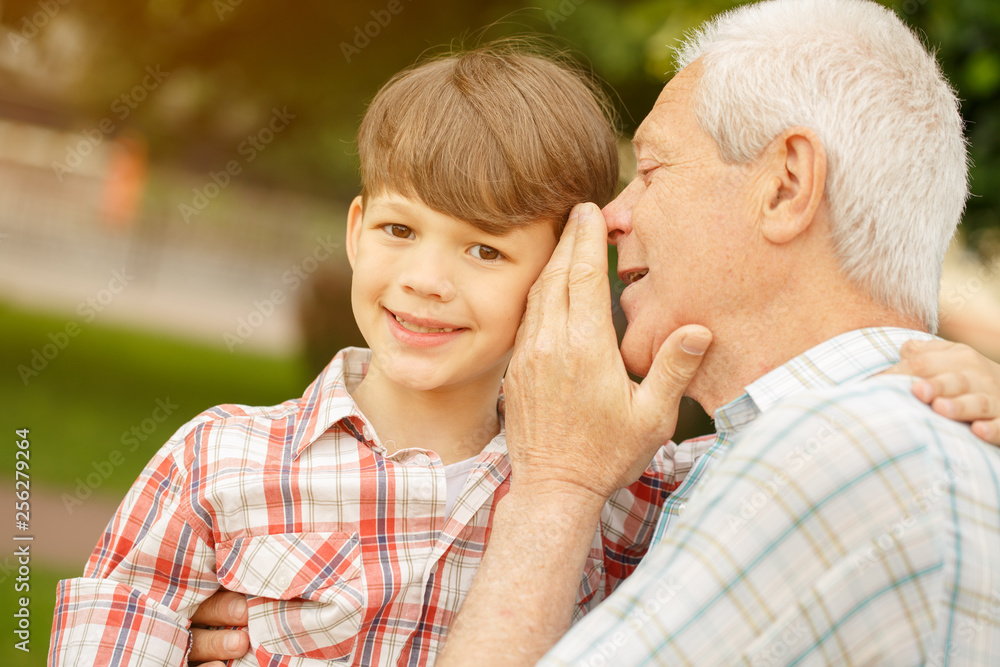 Senior man whispering to his grandson