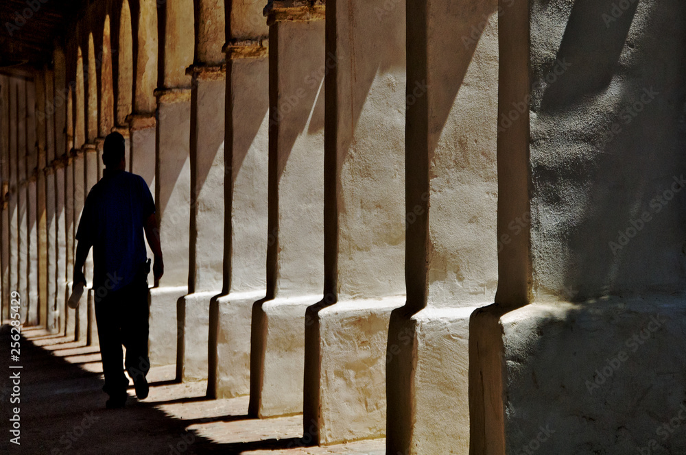 Fototapeta premium Columns and Man Walking Away, Mission San Miguel, California 