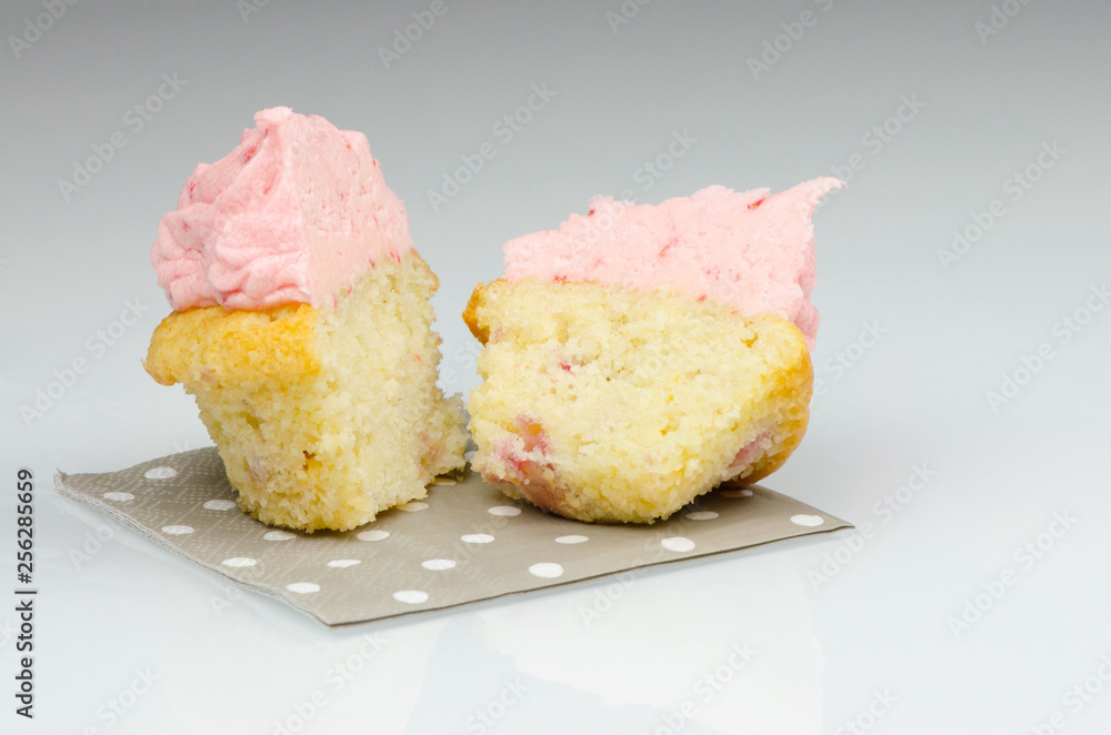 Strawberry cupcake sliced in half. Delicious pink strawberry cupcake cut in half Strawberry cupcake sliced in half. Delicious pink strawberry cupcake cut in half