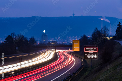 Germany, Stuttgart, Warning sign for particulate pollution alert and traffic in the evening photo