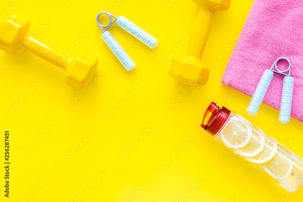 workout with bars, bottle of water and wrist builder yellow background top view mockup workout with bars, bottle of water and wrist builder yellow background top view mockup