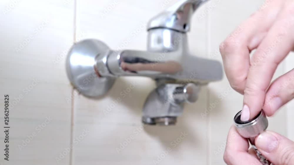 Female hands inserting a rubber gasket into the hose from a bathtub faucet - plumbing repairs and DIY concept Female hands inserting a rubber gasket into the hose from a bathtub faucet - plumbing repairs and DIY concept