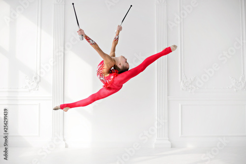 Little girl gymnast, performs various gymnastic and fitness exercises. photo