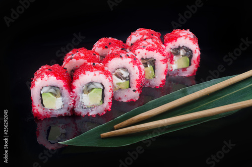 sushi roll with flying fish roe on black background