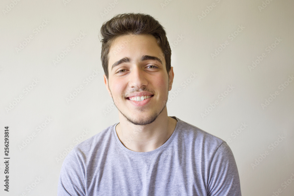 Portrait of smiling handsome man looking at camera isolated on gray background.