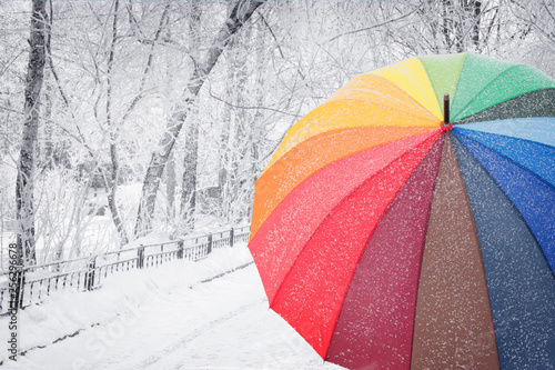 Rainbow colored umbrella on winter street