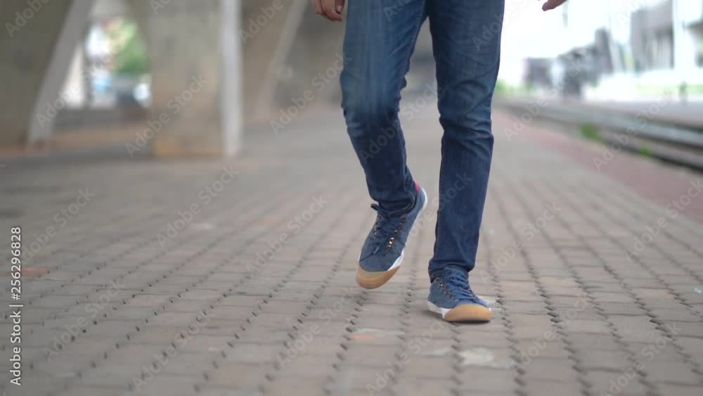 Slow Motion, Close up of man legs in blue jeans walking on the walkway city street Slow Motion, Close up of man legs in blue jeans walking on the walkway city street