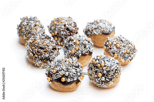 Homemade profiteroles covered with coloured sugar sparkles isolated on white
