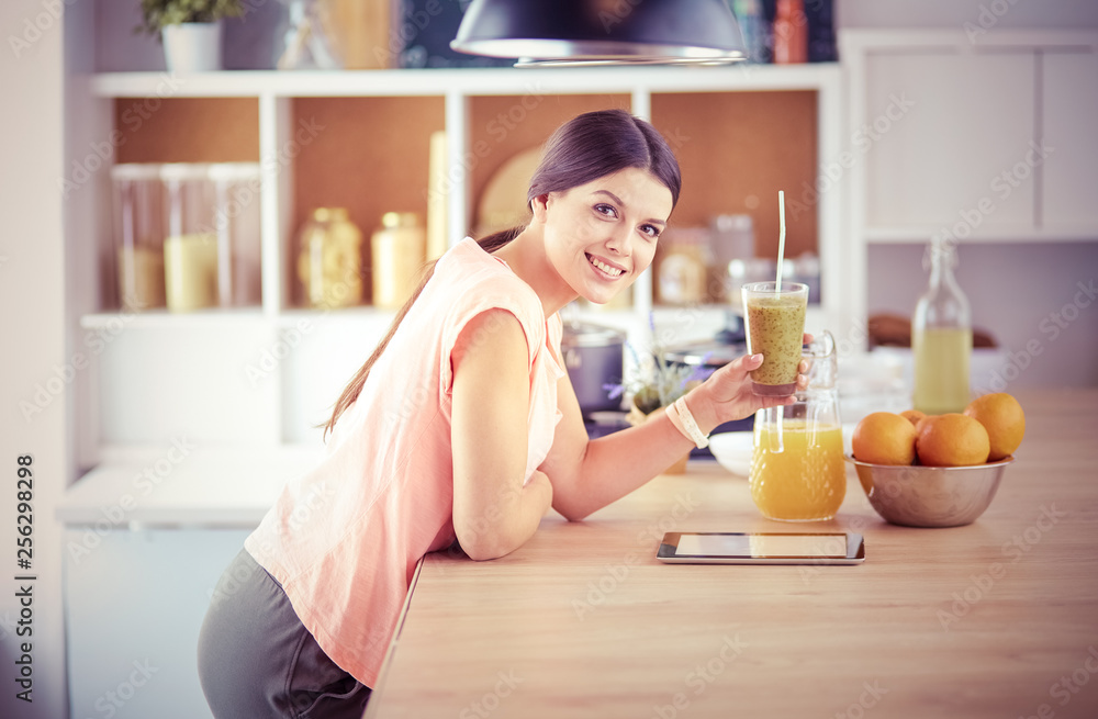 Beautiful young woman using a digital tablet in the kitchen. Beautiful young woman using a digital tablet in the kitchen.
