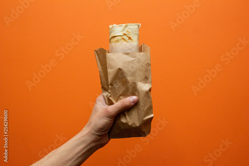 Shawarma sandwich with ingredients in the hand. Sandwich in pita bread. Burrito photo