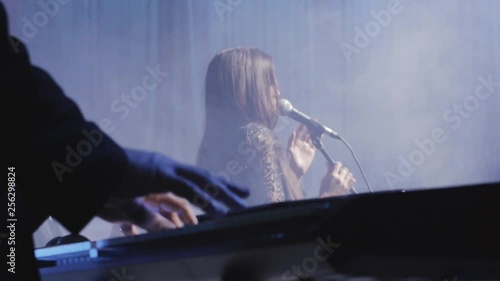 The singer sings on stage to the accompaniment of the synthesizer photo