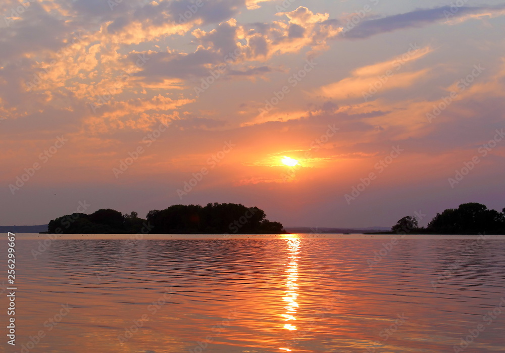 nature. National Reserve. Orange blue sky untouched by man. beautiful sunset and sky The landscape sun sets and a ray of sun is reflected in the water creating a path to the shore. Fabulous islands in nature. National Reserve. Orange blue sky untouched by man. beautiful sunset and sky The landscape sun sets and a ray of sun is reflected in the water creating a path to the shore. Fabulous islands in