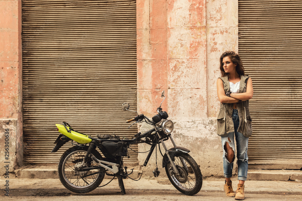 Fototapeta premium Woman is posing beside old motorcycles