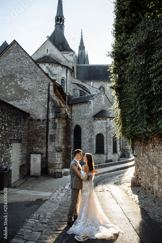 Attractive modernt newlyweds hugging and kissing on the street of the old town. Wedding day photo