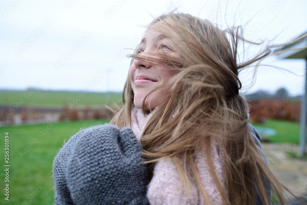 Portrait of smiling girl with blowing hair in winter looking up Portrait of smiling girl with blowing hair in winter looking up
