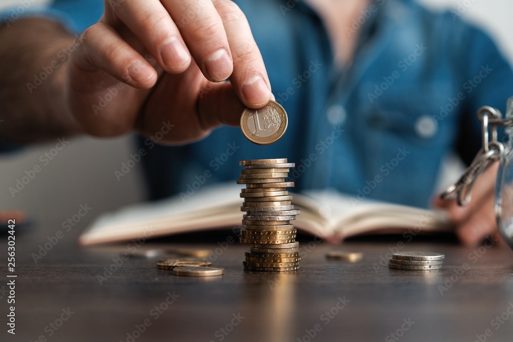 Business man putting a coin on coins stack saving bank and account for his money all in finance accounting concept. Business man putting a coin on coins stack saving bank and account for his money all in finance accounting concept.