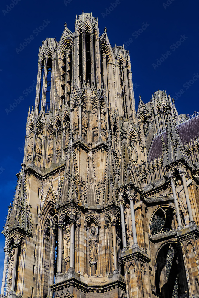 Fototapeta premium Architectural fragments of Reims Notre-Dame cathedral. Notre-Dame de Reims Cathedral (Our Lady of Reims, 1275) is Roman Catholic Church in Reims. Champagne-ardenne, France.