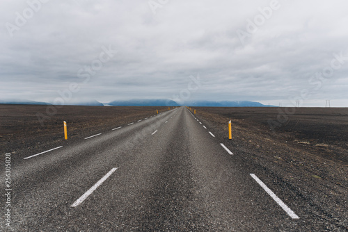 The road between the mountains and the hills. Asphalt road in Iceland. The road is in the field.