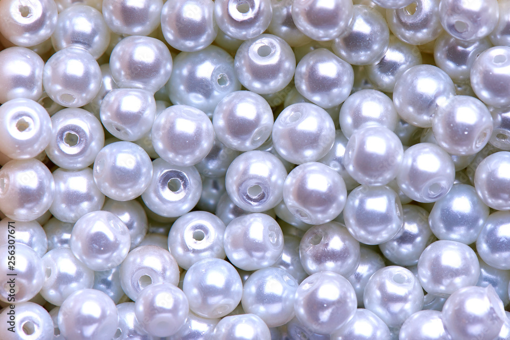 Background of white decorative pearls close-up.